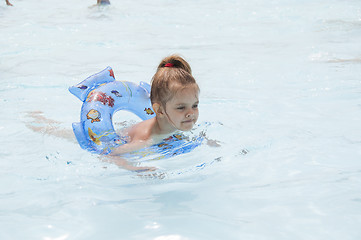 Image showing Four-year-old girl swimming in pool on a circle