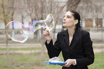 Image showing girl inflates a big bubble in the street