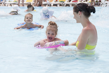 Image showing mother and two daughters are swimming in a public pool