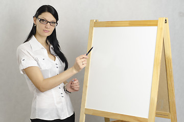 Image showing Business girl with glasses shows marker on white board