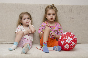 Image showing Two little girls sitting on the couch with a ball