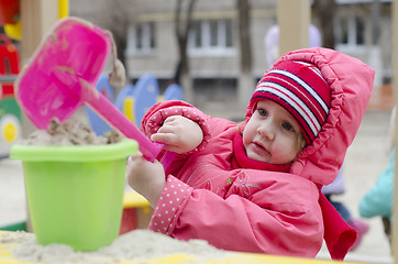 Image showing little girl pours sand bucket in sandbox