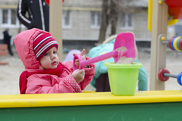 Image showing little girl pours sand bucket in sandbox