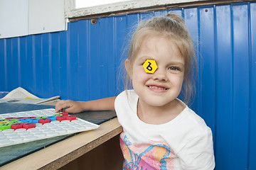 Image showing Girl stuck in eye mosaic with letter and smiles