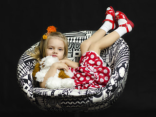 Image showing little girl with a soft toy on chair