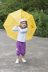 Image showing Small girl standing with the yellow umbrella