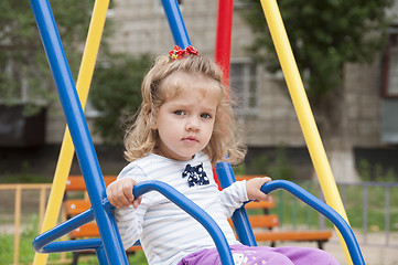 Image showing Girl riding on a swing in the Playground