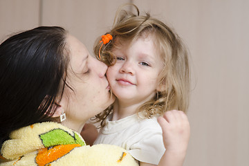 Image showing Mom hugs and kisses awakened fuzzy-looking child