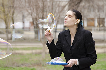 Image showing girl inflates a big bubble, the bubble bursts