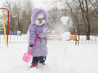 Image showing Four year old girl threw herself with snow shovels