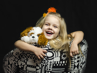 Image showing little girl with a soft toy on chair