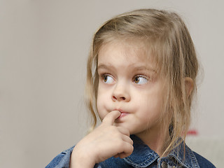 Image showing Four-year-old girl with finger in mouth look left