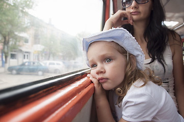 Image showing Sad and tired girl looks through window in tram