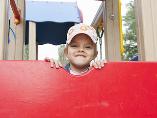 Image showing girl peeks out from behind shield playing on Playground