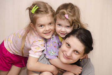 Image showing Merry and happy children a mother embracing look in frame