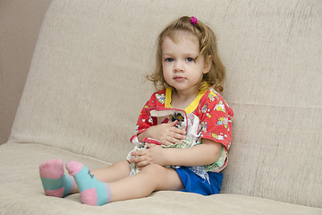 Image showing  little girl was sitting on sofa with scarves in hands of