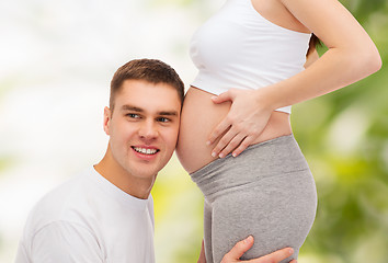 Image showing happy father listening belly of his pregnant wife