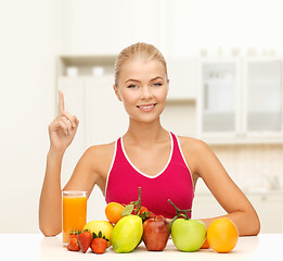 Image showing woman with juice and fruits holding finger up