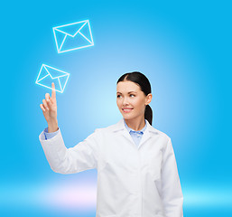 Image showing smiling female doctor pointing to envelope