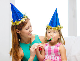 Image showing mother and daughter in blue hats with favor horns