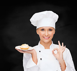 Image showing smiling female chef with cake on plate