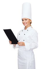 Image showing smiling female chef with black blank paper