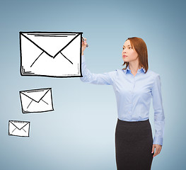 Image showing businesswoman drawing envelope on virtual screen