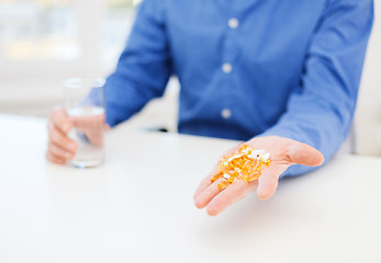 Image showing close up of male hand showing lot of pills