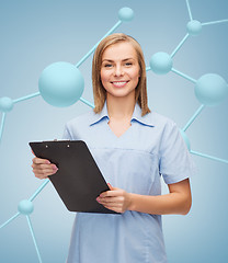 Image showing smiling female doctor or nurse with clipboard