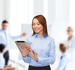 Image showing smiling woman looking at tablet pc at office