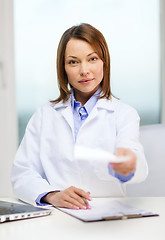 Image showing busy doctor with laptop computer and clipboard