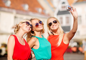 Image showing three beautiful girls taking picture in the city