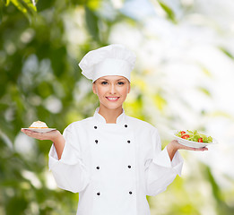 Image showing smiling female chef with salad and cake on plates