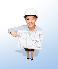 Image showing businesswoman in helmet showing with blueprint