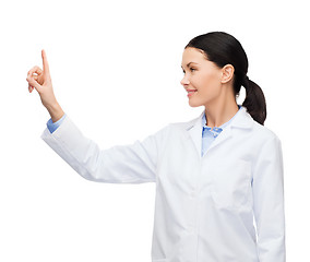 Image showing smiling female doctor pointing to something