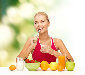 Image showing young woman eating healthy breakfast