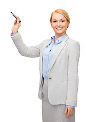 Image showing businesswoman writing something in air with marker