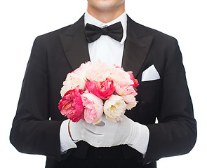Image showing man in tail-coat with flower bouquet