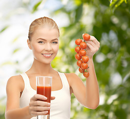 Image showing woman holding glass of juice and tomatoes