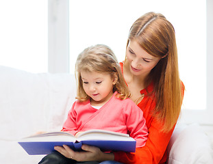 Image showing happy mother and daughter with book