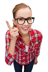 Image showing smiling teenager in eyeglasses with finger up