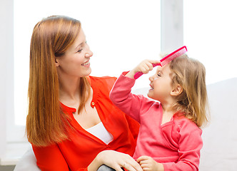 Image showing happy mother and daughter with comb