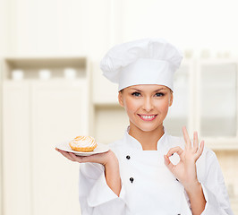 Image showing smiling female chef with cake on plate