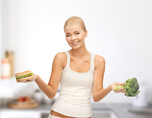 Image showing smiling woman with broccoli and hamburger