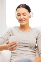 Image showing woman with smartphone and headphones at home