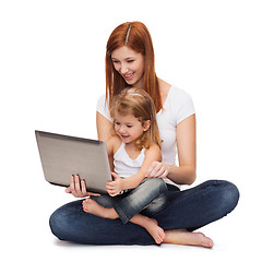 Image showing happy mother with adorable little girl and laptop