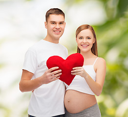 Image showing happy young family expecting child with big heart