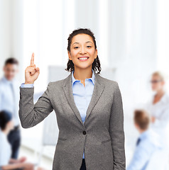 Image showing smiling businesswoman with her finger up at office