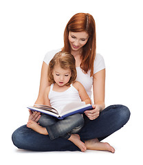 Image showing happy mother with adorable little girl and book