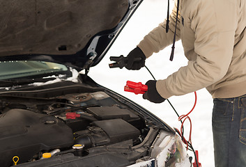 Image showing closeup of man under bonnet with starter cables